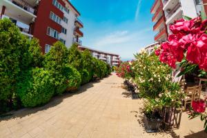 a corridor of an apartment building with flowers and plants at Panorama Fort Beach in Sveti Vlas