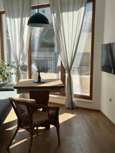 stół i krzesło w pokoju z oknami w obiekcie Atelier 26 w Warnie