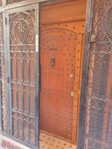 eine Holztür mit einem Metalltor in einem Gebäude in der Unterkunft Riad Rayan in Marrakesch