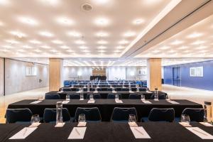 a large room with rows of tables and chairs at Hotel Castellon Center Affiliated by Meliá in Castellón de la Plana