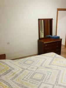 a bedroom with a bed and a dresser and a mirror at Ezero apartamentai in Šiauliai