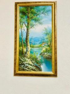 a framed picture of a painting of a river at Ezero apartamentai in Šiauliai
