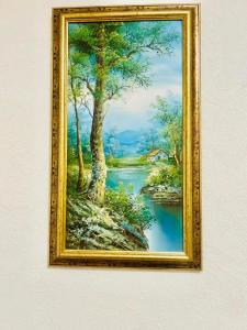 un cuadro enmarcado de una pintura de un río en Ezero apartamentai, en Šiauliai