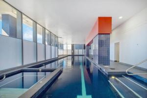 a large swimming pool in a large building at Lovely home with pool in Zetland in Sydney