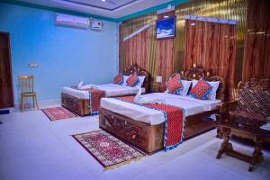 Duas camas num quarto com paredes azuis em Hotel Anita em Baripāda