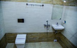 a bathroom with a toilet and a sink at Hotel Anita in Baripāda