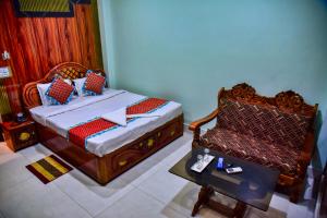 a bedroom with a bed and a chair and a table at Hotel Anita in Baripāda