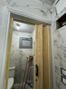 ein Bad mit einem TV an der Wand in der Unterkunft شقه صغيره فندقيه في موقع مميز جديده وفرش وموبيليا جديده in Mansoura