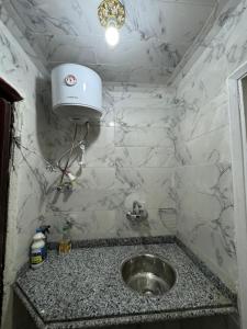 ein Badezimmer mit einem Waschbecken und einem Licht an der Wand in der Unterkunft شقه صغيره فندقيه في موقع مميز جديده وفرش وموبيليا جديده in Mansoura