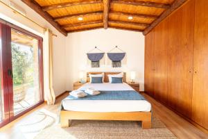 ein Schlafzimmer mit einem Bett und einem großen Fenster in der Unterkunft Assento do Cávado by House and People in Valdosende