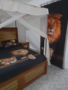 um quarto com um mural de leão ao lado de uma cama em La doré du Sénégal em Somone