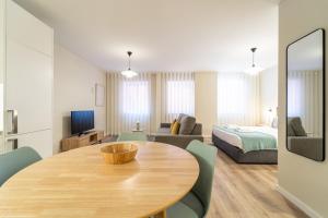 un soggiorno con tavolo in legno e una camera da letto di On The Square Studio - City Center by House and People a Braga