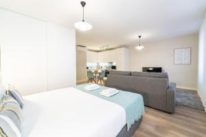 una camera da letto con un letto grande e un divano di On The Square Studio - City Center by House and People a Braga