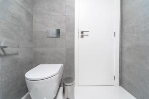 baño con aseo blanco y puerta en On The Square Studio - City Center by House and People, en Braga