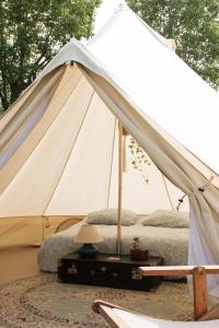une grande tente blanche avec un canapé et une lampe dans l'établissement Aparra Surfcamp Capbreton, à Capbreton