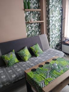 a couch with pillows and a table in a room at Apartament RESET 2 pokojowy in Ustroń