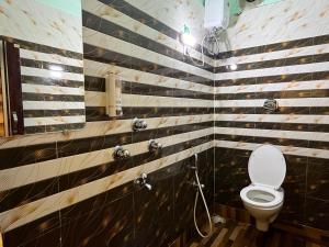 a bathroom with a toilet and black and white stripes at OYO Hotel Sweet Dream in Kolkata