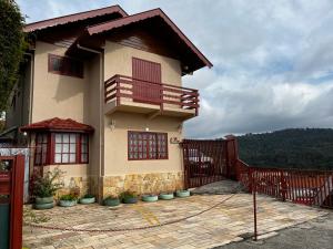 ein Haus mit einem Balkon und einem Zaun in der Unterkunft sonho de valsa in Campos do Jordão