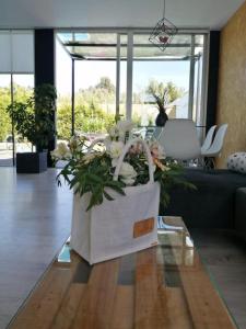 una bolsa blanca con flores sobre una mesa en la sala de estar en Casa Calima en Esteiro