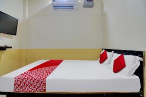 a bedroom with a bed with red and white pillows at Super OYO Flagship Hotel Vinit Lodging in Nagpur