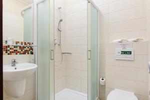 a bathroom with a shower and a sink and a toilet at Lila Medical SPA in Ciechocinek