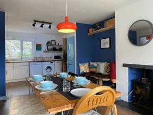 a dining room with a table and a kitchen at Bungalow, mountain and sea views parking in Aberdyfi