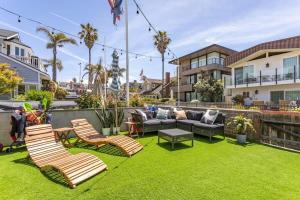 a backyard with a couch and chairs and grass at Hermosa Bungalow 1920s Charm Steps to the Strand in Hermosa Beach