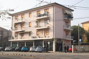 a pink building with cars parked in front of it at BB Bella Venice in Marghera