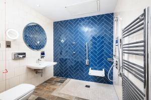 Łazienka z umywalką i niebieskimi płytkami w obiekcie Hotel Indigo - Edinburgh - Princes Street, an IHG Hotel w Edynburgu