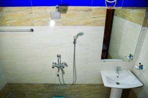 y baño con ducha y lavamanos. en Hotel Anita, en Baripāda