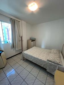 um quarto com uma cama e uma janela em Apto 2 dormitórios em Balneário Camboriú no Balneário Camboriú