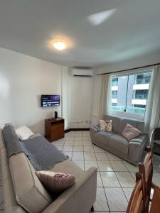 uma sala de estar com um sofá e um sofá e uma televisão em Apto 2 dormitórios em Balneário Camboriú no Balneário Camboriú