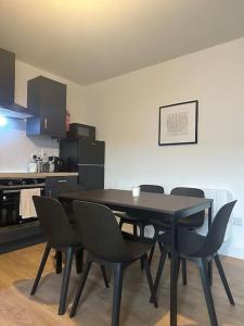 Modern & Spacious Central Apt في دبلن: طاولة طعام سوداء وكراسي في مطبخ