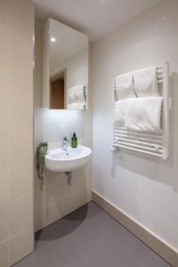 La salle de bains est pourvue d'un lavabo, d'un miroir et de serviettes. dans l'établissement Studio at Florence Dock, à Londres