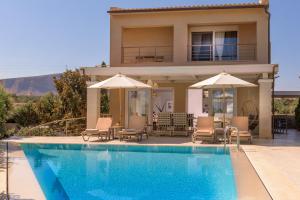 a house with a swimming pool in front of a house at Villa Penelope in Gouves