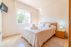 a white bedroom with a bed and a window at La Torre: casa perfecta con piscina privada in Pobla de Montornés +30 photos