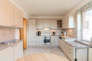a large kitchen with white cabinets and a window at Ferienwohnung Kiel Canal Grande in Kiel