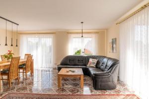 a living room with a leather couch and a table at Ferienwohnung Kiel Canal Grande in Kiel