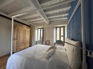 um quarto com uma grande cama branca com paredes azuis em Casa Stella a due passi da Orta em Ameno