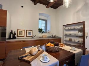 een keuken met een tafel en een fruitschaal bij Casa Stella a due passi da Orta in Ameno