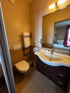 a bathroom with a sink and a toilet and a mirror at O Barcaiolo in Conflans-Sainte-Honorine