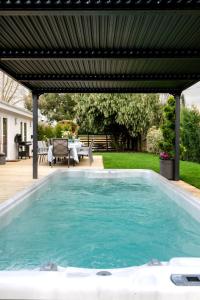 una piscina con pérgola en un patio trasero en Paisley Cottage, en Sandwich