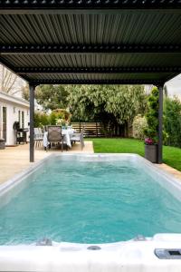 a swimming pool with a pergola in a backyard at Paisley Cottage in Sandwich
