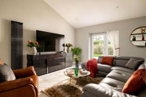 a living room with a couch and a tv at Paisley Cottage in Sandwich