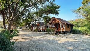 une rangée de cottages sur le côté d'une route dans l'établissement อิงน้ำท่าจีน (ท่าจีนรีสอร์ท), à Suphanburi