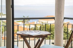 dos copas de vino sentadas en una mesa en un balcón en Sea View Apartment en Santa Cruz