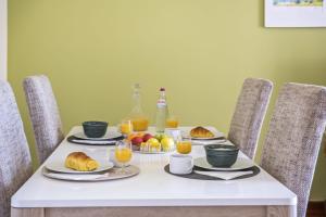 a table with breakfast foods and orange juice at Sea View Apartment in Santa Cruz