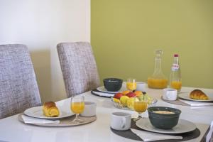 una mesa con platos de comida y vasos de zumo de naranja en Sea View Apartment en Santa Cruz