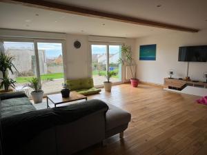 a living room with a couch and a tv at La maison du bon air in Wimereux