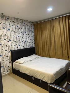 1 dormitorio con 1 cama y una ventana con cortinas en Hotel Global Subang, en Subang Jaya